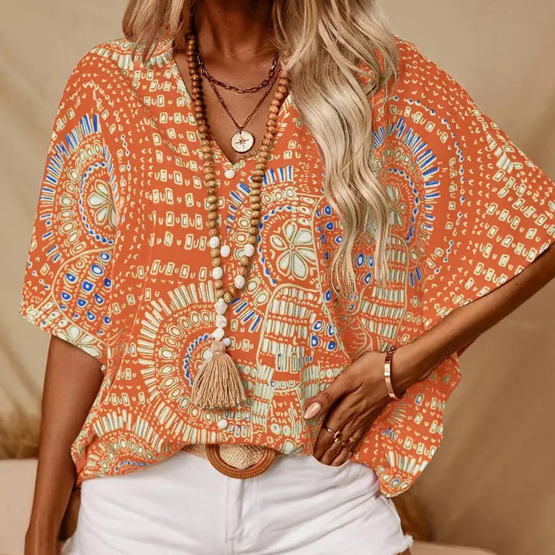 Top holgado de mujer con cuello en V y estampado, con mangas murciélago, ideal para vacaciones.
